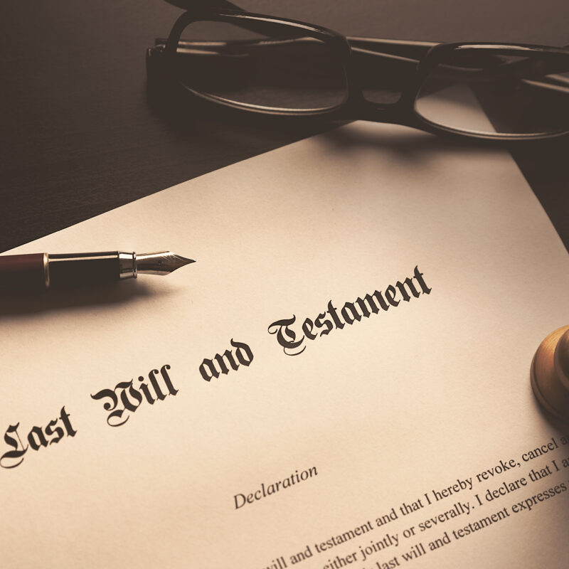 Glasses, a pen, and a stamp, set on a will