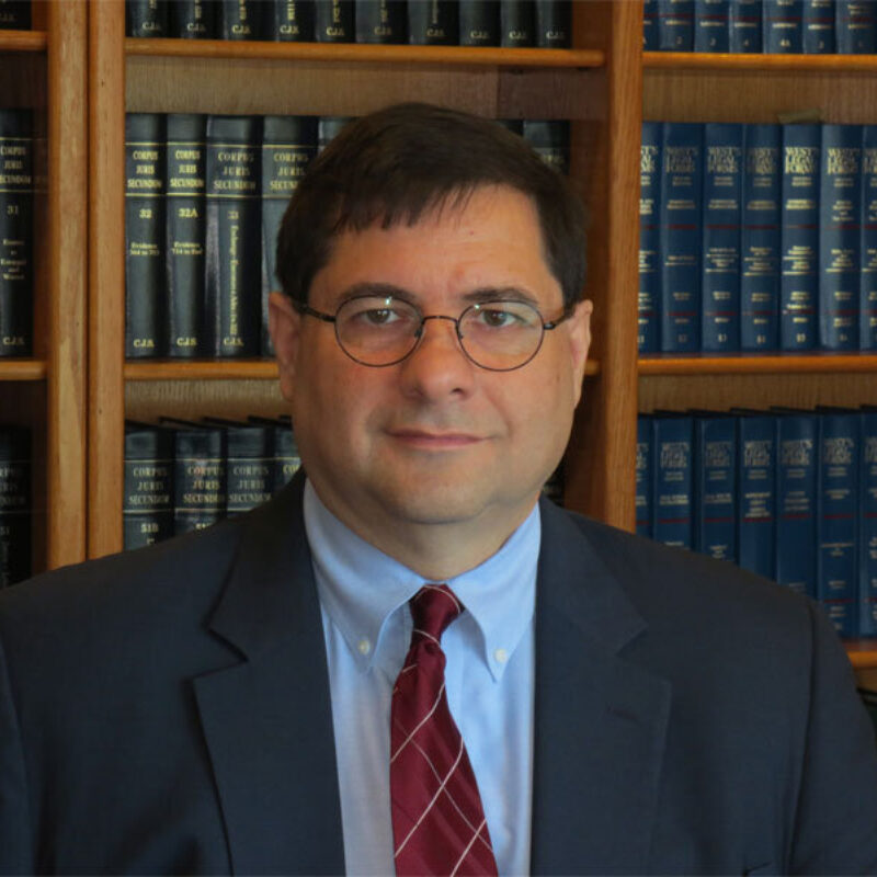 Attorney Buzzi in front of bookcases